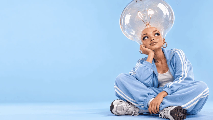Character in a blue tracksuit with a giant light bulb as a hairstyle